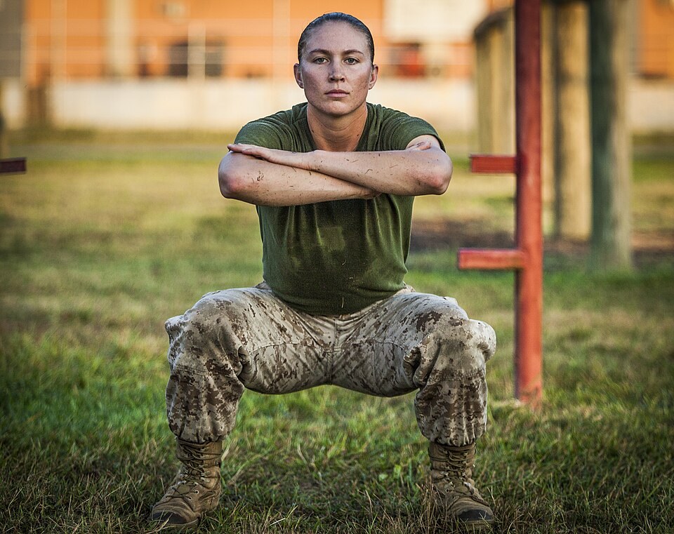 Person performing a bodyweight squat with arms crossed (Wikimedia Commons photo)