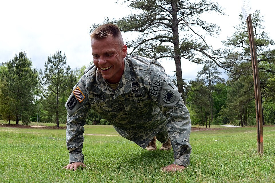 Soldier holding the top of a full push-up on grass (Wikimedia Commons photo)
