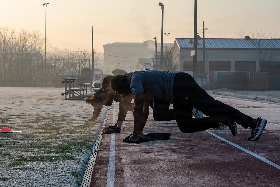 Guardians in a high plank driving one knee forward during mountain climbers (Wikimedia Commons photo)